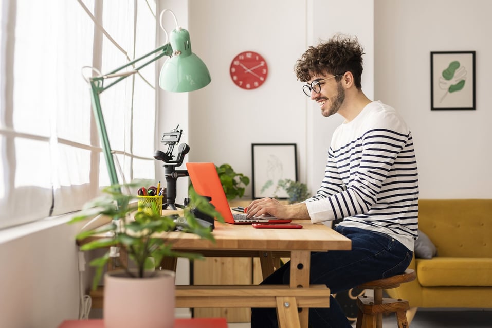 man-happy-working-on-laptop-benefits-of-eustress