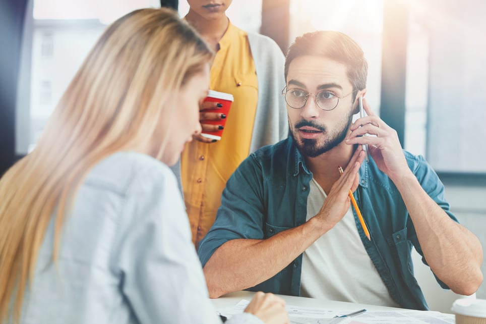 man-on-mobile-phone-distracted-by-coworker-how-to-avoid-interruptions-at-work