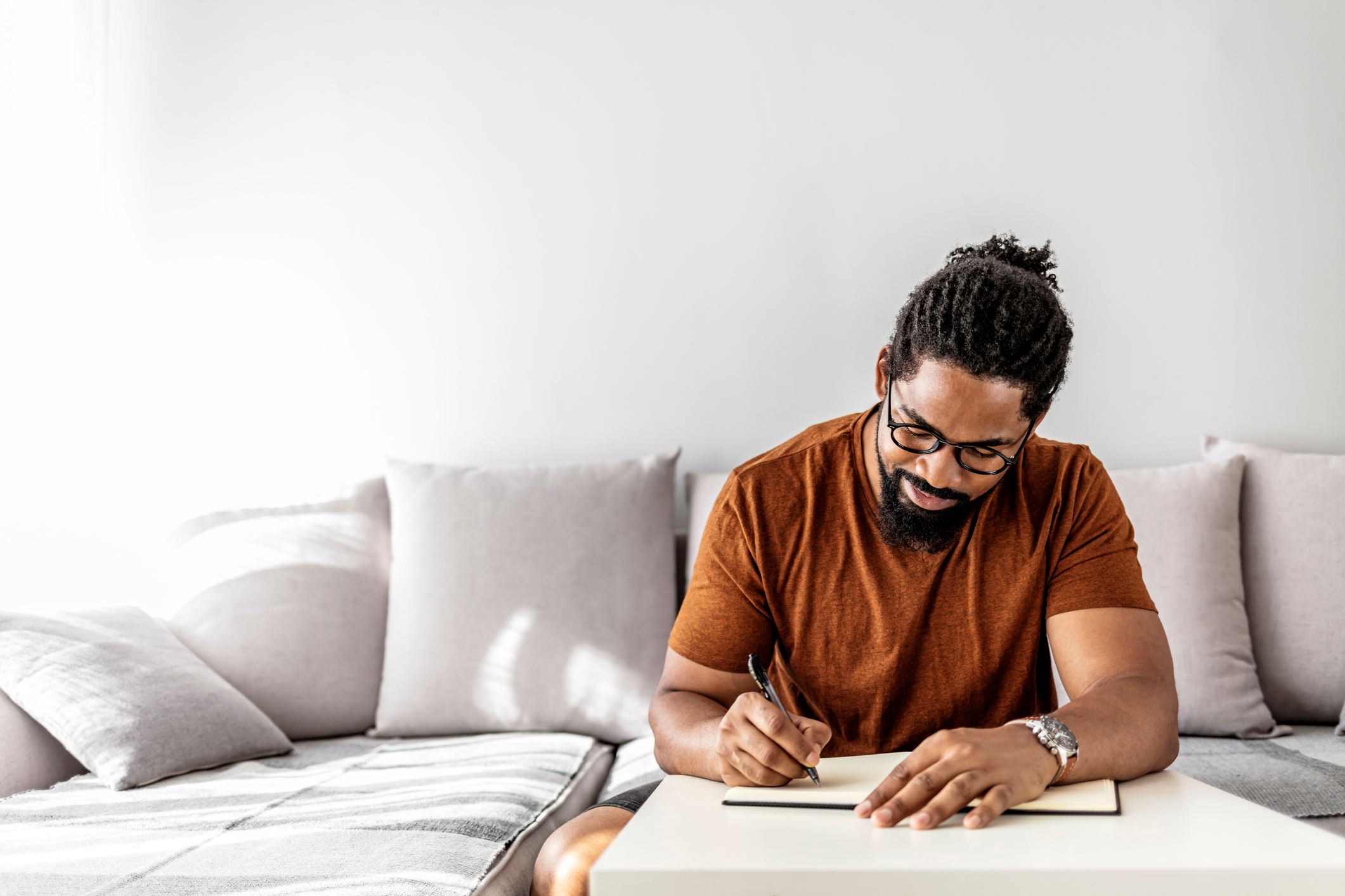 man-with-notepad-and-pen-sitting-on-sofa-professional-references