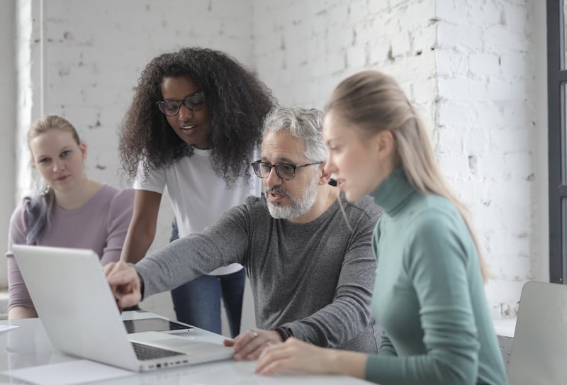 older-manager-showing-something-to-employees-at-meeting-Thank-you-for-your-leadership-and-vision