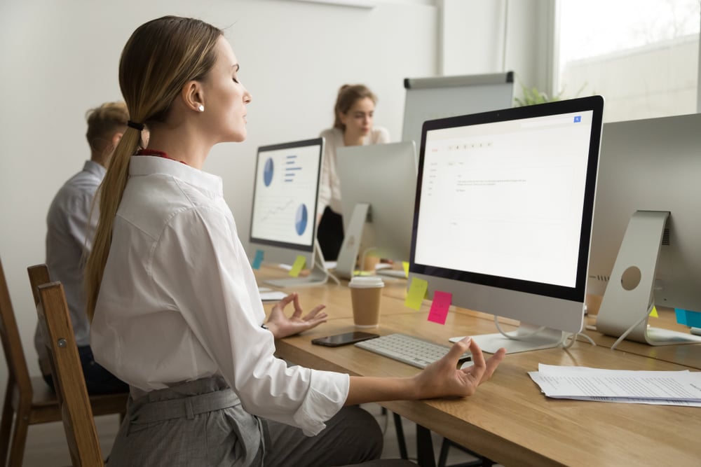 peaceful-young-businesswoman-meditating-at-office-self-compassion-and-motivation