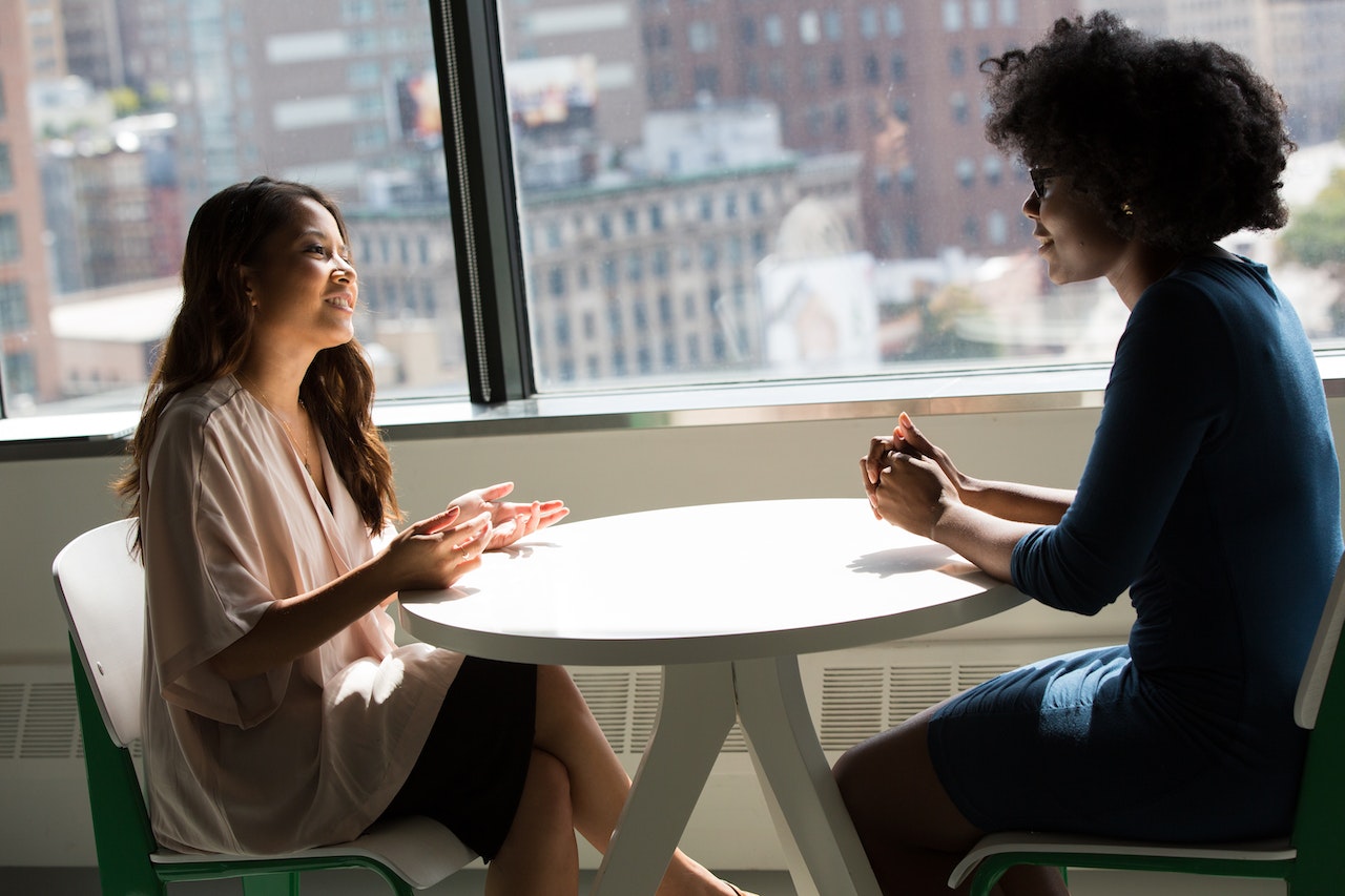 two-woman-talking-in-table-benefits-of-mentorship