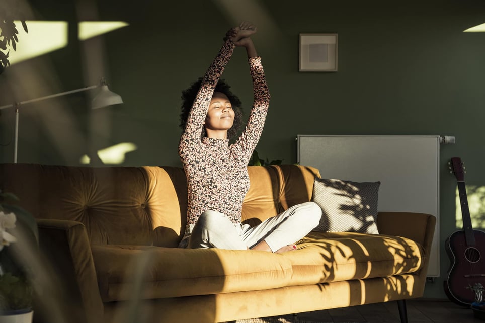 woman-with-hands-raised-sitting-on-sofa