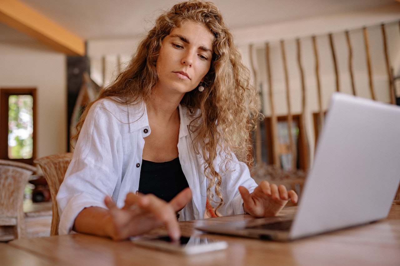 woman-working-from-home-using-his-laptop-and-phone-Eisenhower-Matrix